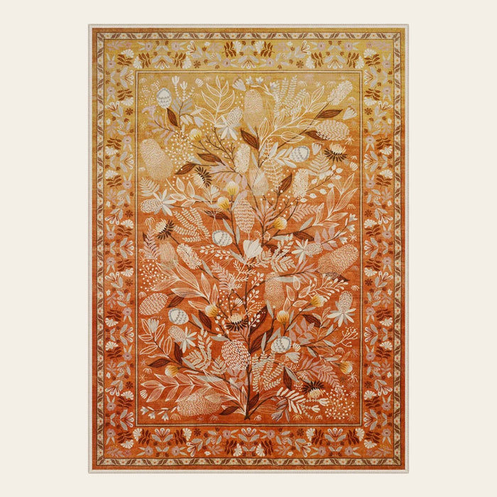 Covaba modern natural botanical floral area rug in golden wheat, shown flat on a plain ivory backdrop