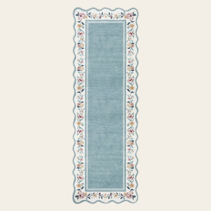 Covaba vintage floral scalloped runner rug in dusty blue, shown flat on a plain ivory backdrop