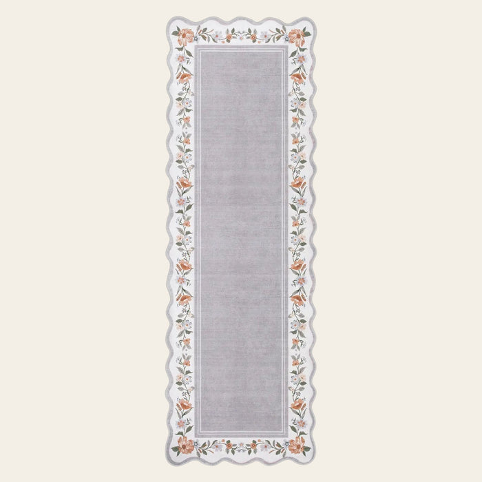 Covaba vintage floral scalloped runner rug in muted plum, shown flat on a plain ivory backdrop