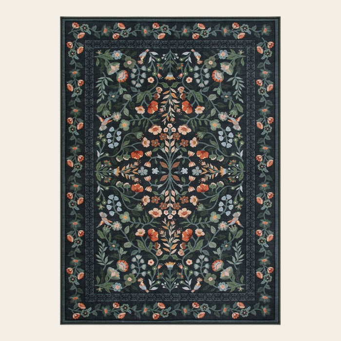 Covaba vintage floral area rug in ink black, shown flat on a plain ivory backdrop