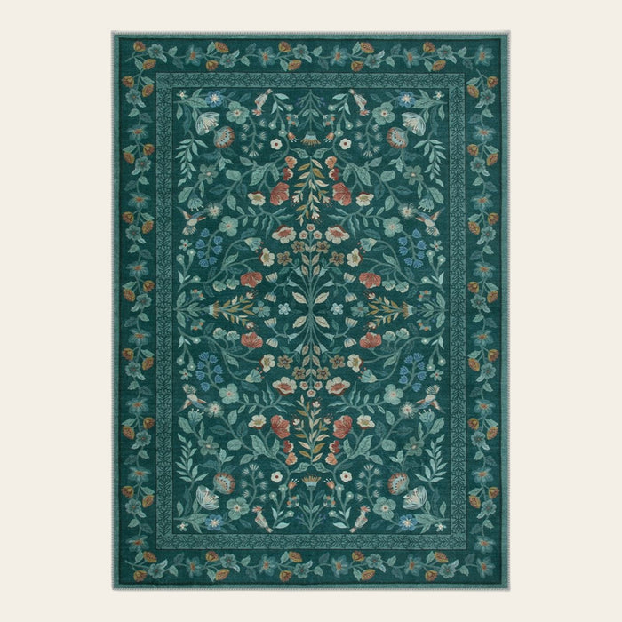 Covaba vintage floral area rug in deep green, shown flat on a plain ivory backdrop