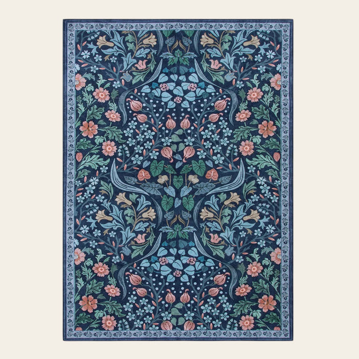 Covaba maximalism vibrant floral area rug in stormy blue, shown flat on a plain ivory backdrop