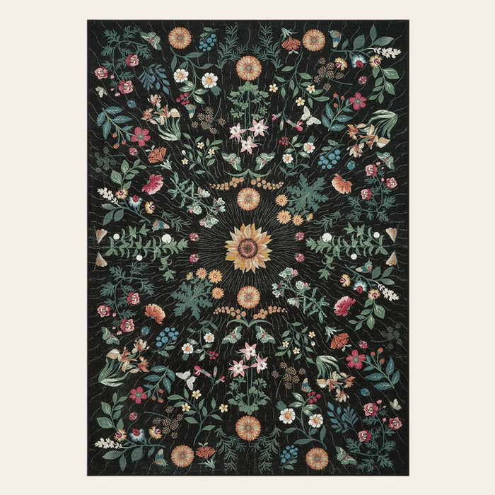 Covaba boho botanical floral area rug in ink black, shown flat on a plain ivory backdrop