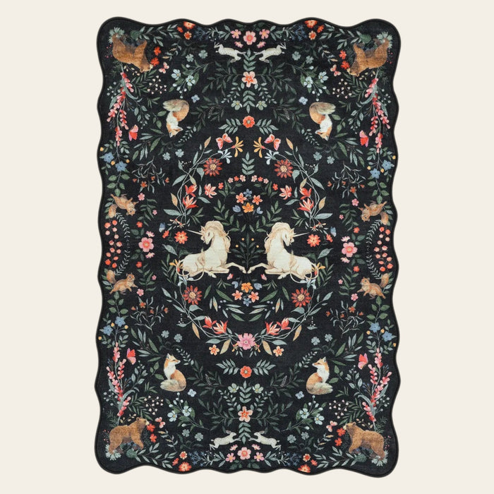 Covaba maximalist unicorn garden scalloped area rug in ink black, shown flat on a plain ivory backdrop