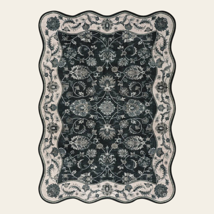 Covaba vintage botanical scalloped area rug in ink black, shown flat on a plain ivory backdrop