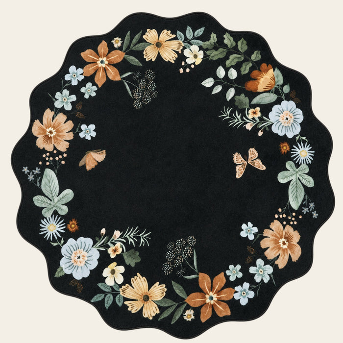 Covaba boho modern parisian floral scalloped round rug in ink black, shown flat on a plain ivory backdrop