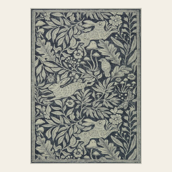 Covaba vintage woodcut forest and rabbit area rug in pearl grey, shown flat on a plain ivory backdrop