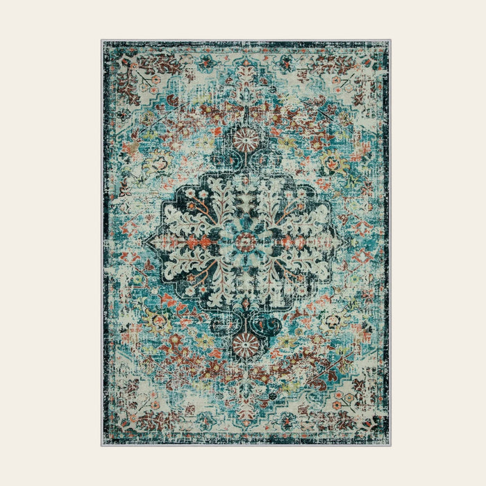 Covaba bohemian floral medallion area rug in teal haze, shown flat on a plain ivory backdrop