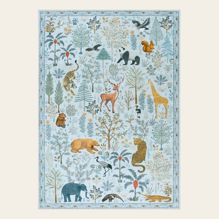Covaba jungle animals area rug in stormy blue, shown flat on a plain ivory backdrop
