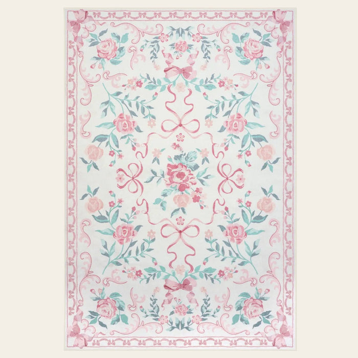 Covaba floral bows area rug in blush clay, shown flat on a plain ivory backdrop