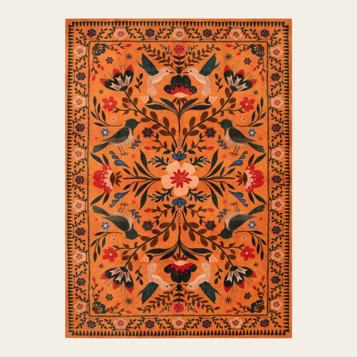 Covaba boho birdsong floral garden area rug in amber clay, shown flat on a plain ivory backdrop