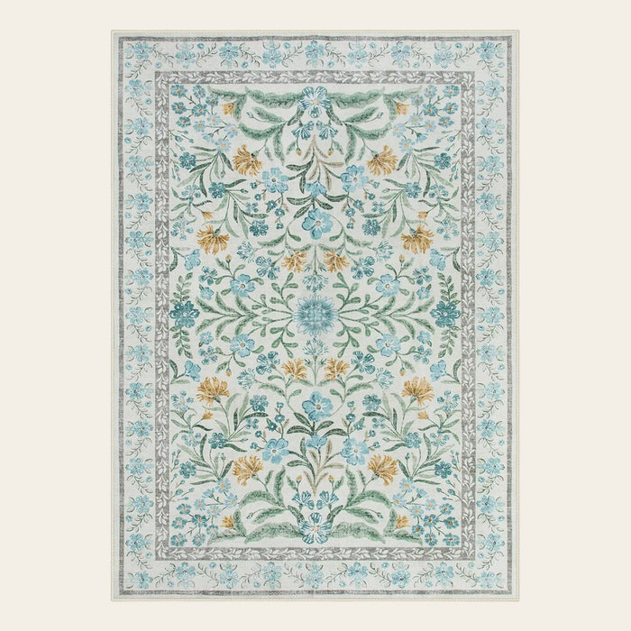 Covaba boho modern parisian garden floral area rug in stormy blue, shown flat on a plain ivory backdrop