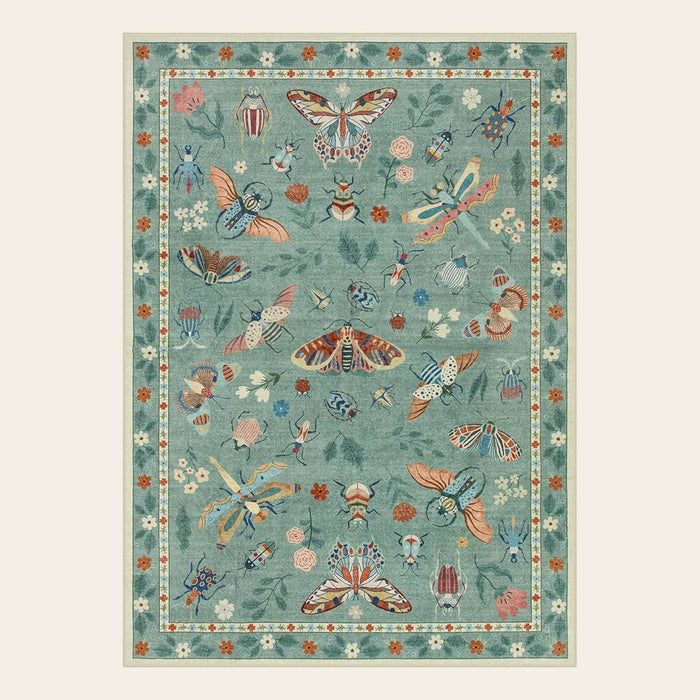 Covaba modern parisian insect area rug in sage mist, shown flat on a plain ivory backdrop
