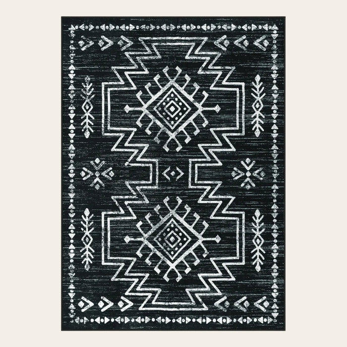 Covaba aztec moroccan distressed area rug in ink black, shown flat on a plain ivory backdrop