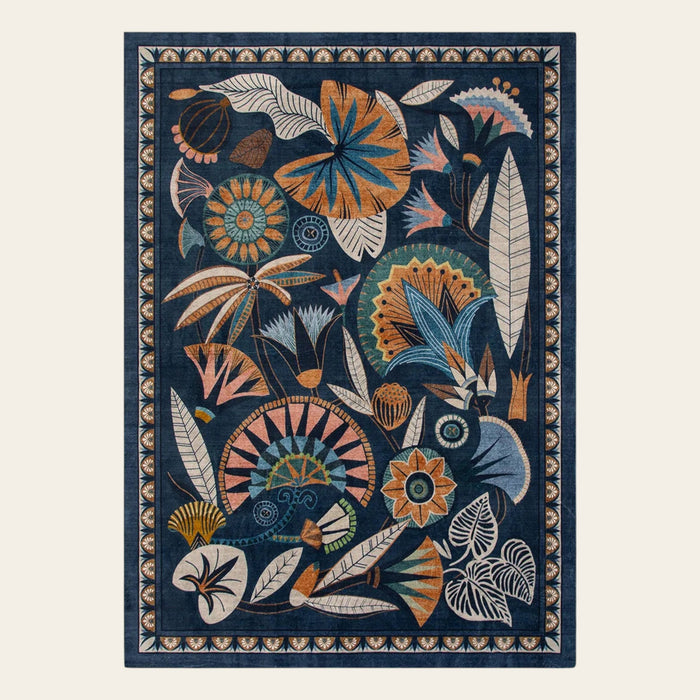 Covaba egyptian-inspired botanical area rug in deep navy, shown flat on a plain ivory backdrop