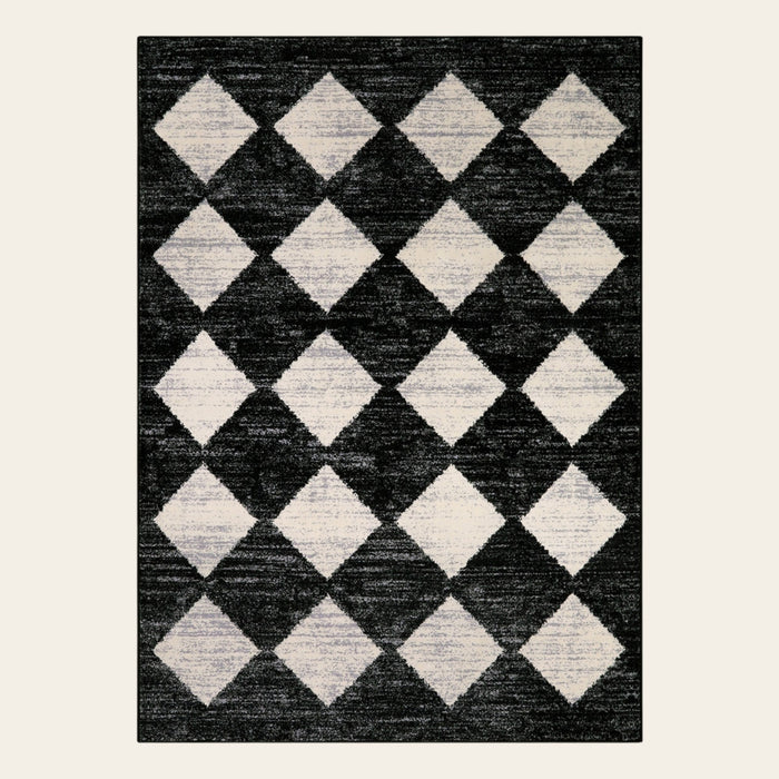 Covaba modern geometric diamond checkered area rug in ink black, shown flat on a plain ivory backdrop