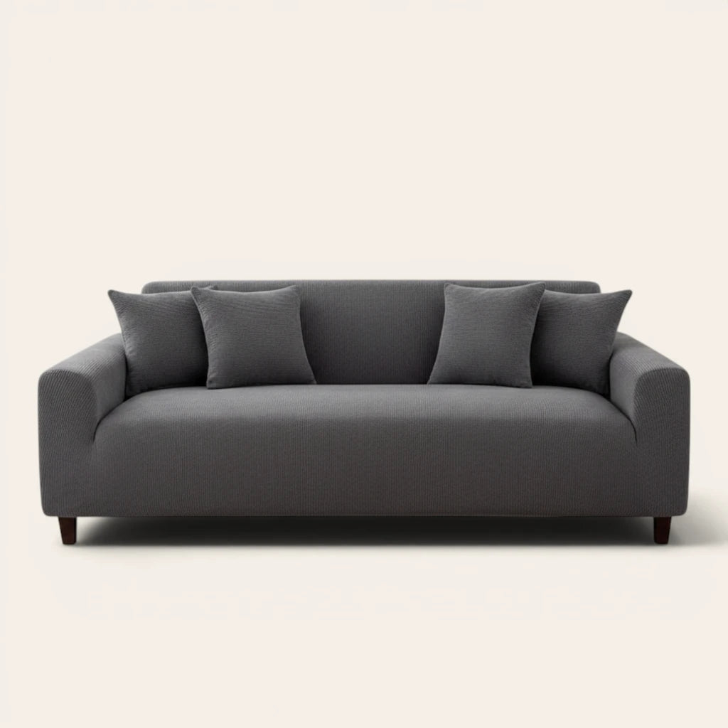 Charcoal gray corduroy stretch cover fitted on a three-seat sofa, front view on ivory backdrop
