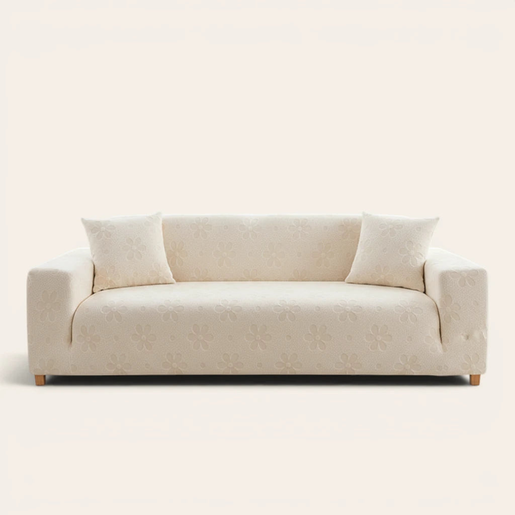 Cream Petal floral sofa cover fitted on a three-seat sofa with matching cushions, front view on ivory