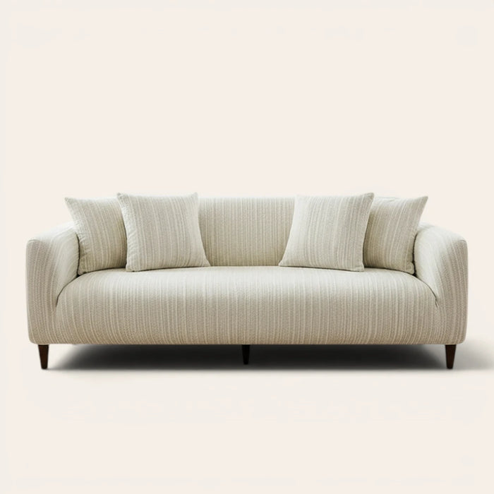 Cream ivory jacquard sofa cover on a three-seater, front view on ivory backdrop with matching cushions