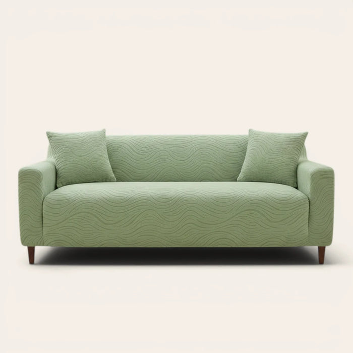 Sage green jacquard sofa cover on a three-seater, front view on ivory backdrop with two matching cushions