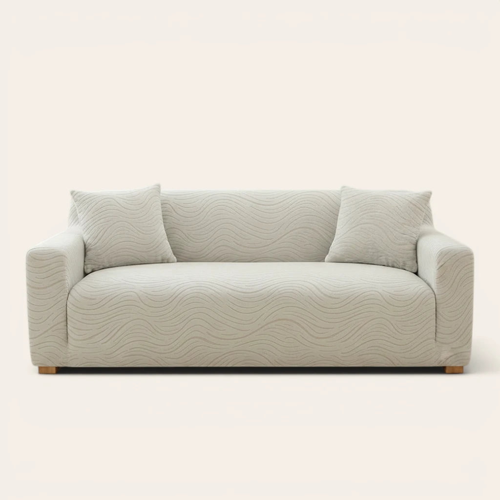 Soft ivory jacquard sofa cover fitted on a three-seater with wave pattern, front view on ivory backdrop