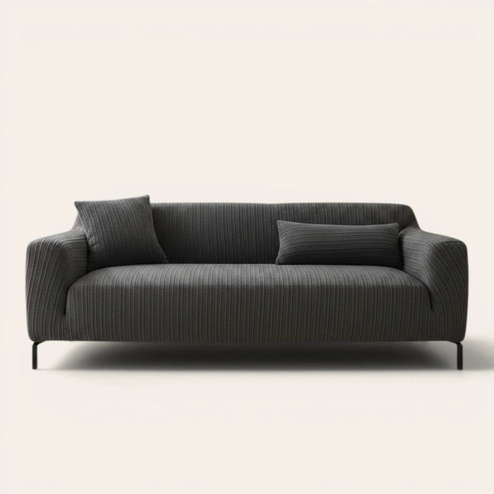 Slate charcoal ribbed knit sofa cover fitted on a three-seat couch with cushions, front view on ivory.