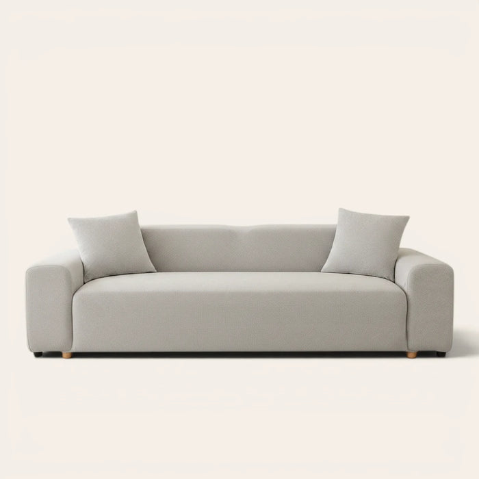 Silver grey smooth sofa cover on a three-seat sofa with matching cushions, front view on ivory