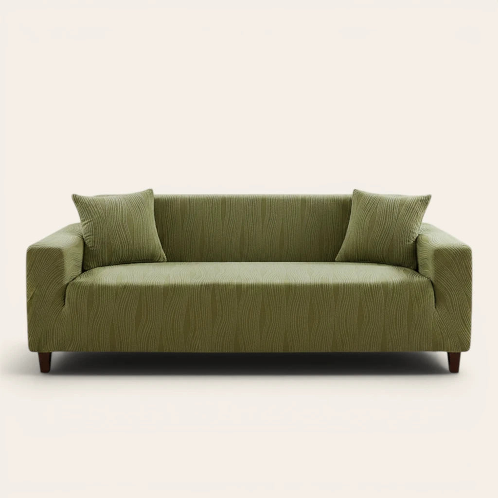 Sage green velvet sofa cover fitted on a three-seat sofa, front view on ivory backdrop