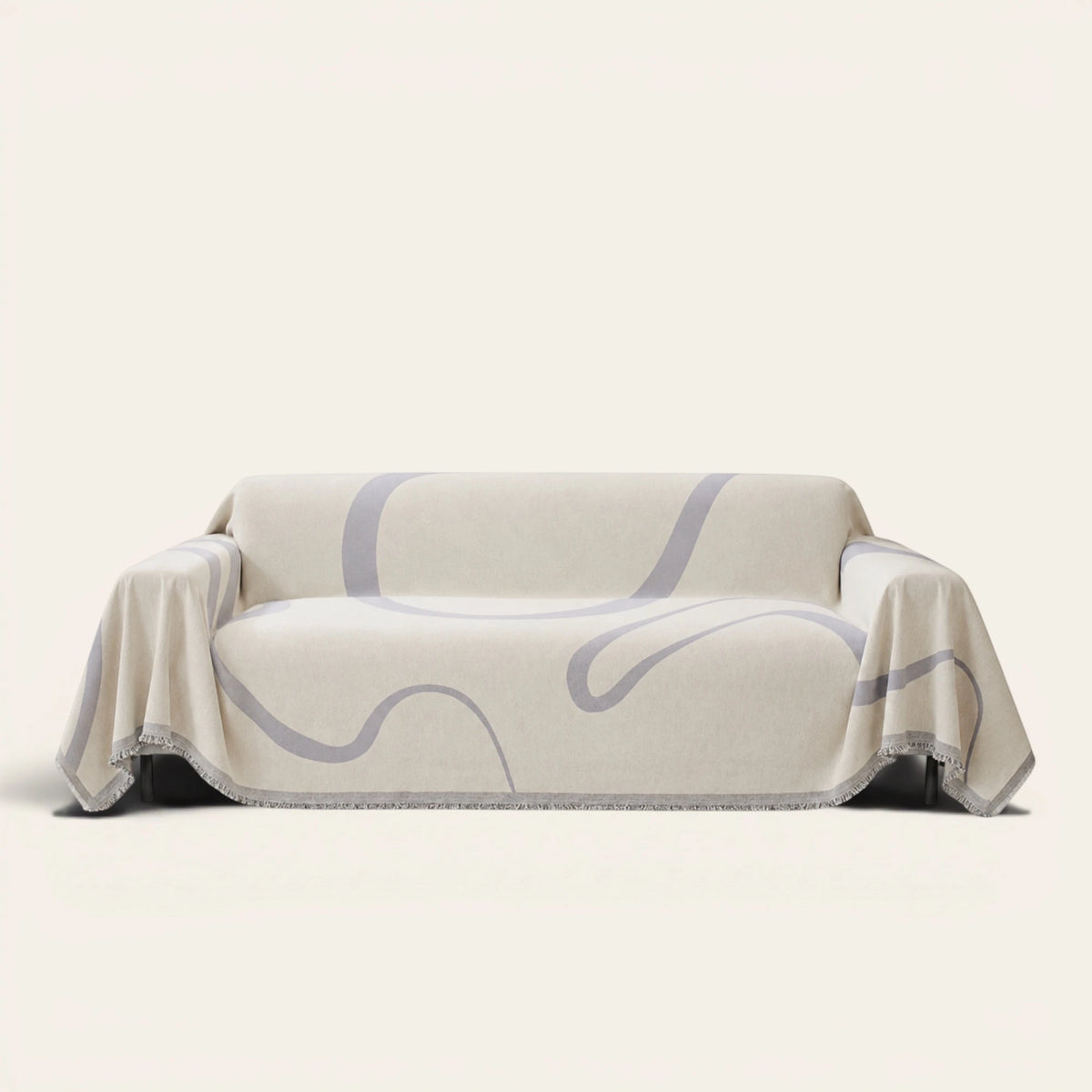 Abstract Muse Monochrome Wave sofa throw draped over a three-seat sofa, front view on ivory