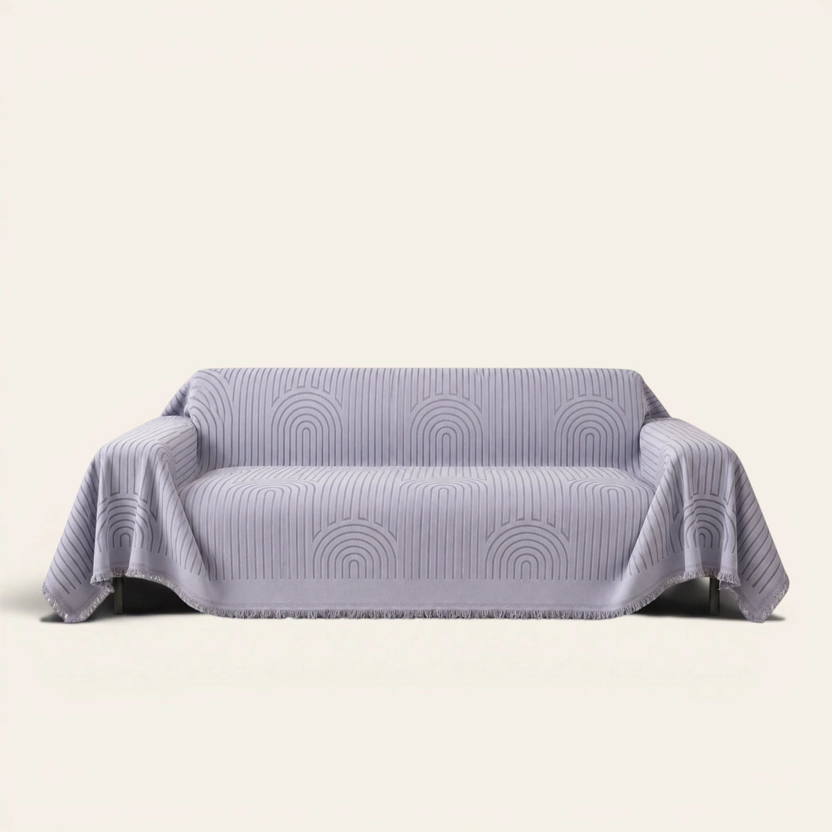 Misty Gray Arcane Ambiance sofa throw draped over a two-seat sofa, front view on ivory background, arched line pattern