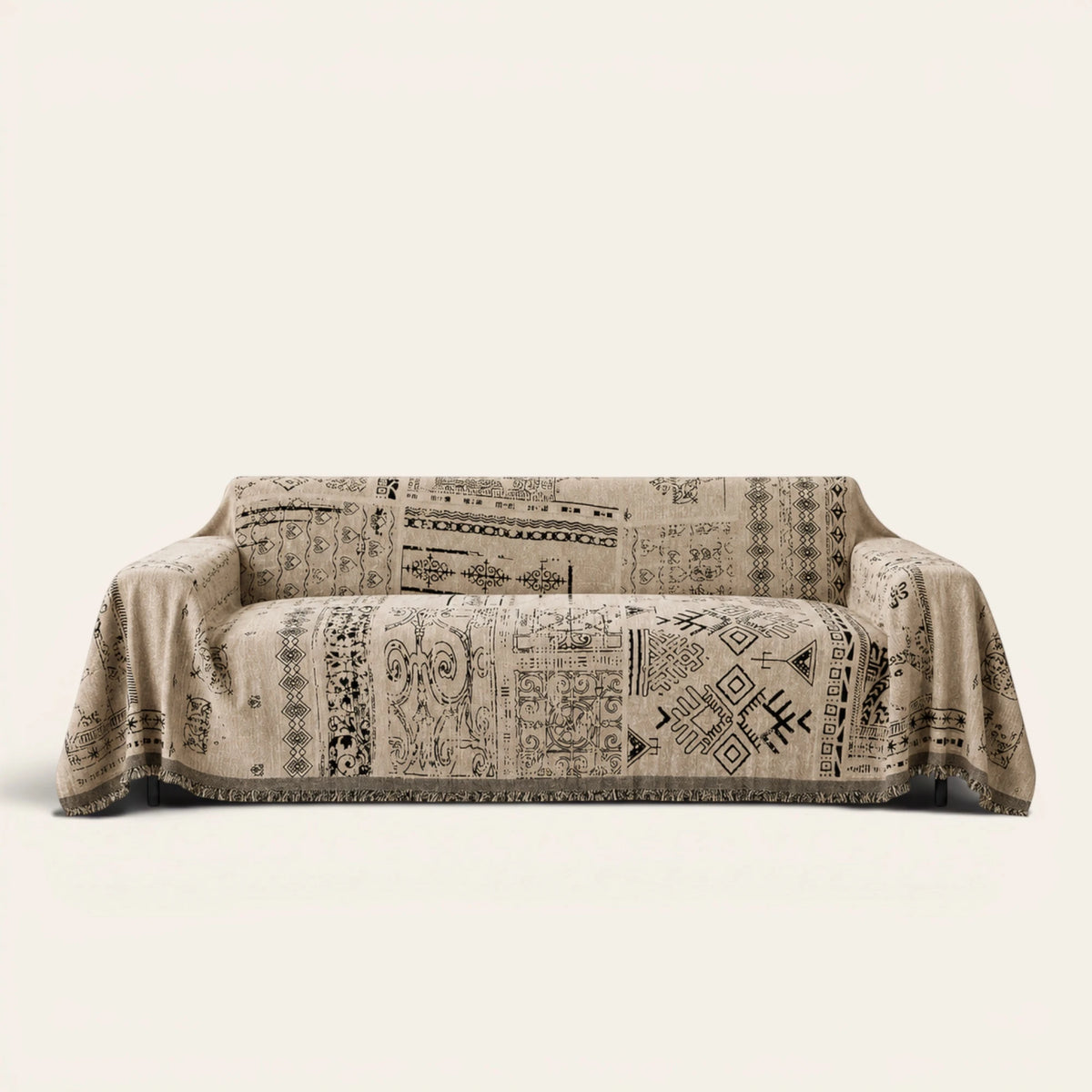 Sand Beige Artisan Glyph throw draped over a two-seat sofa on ivory background