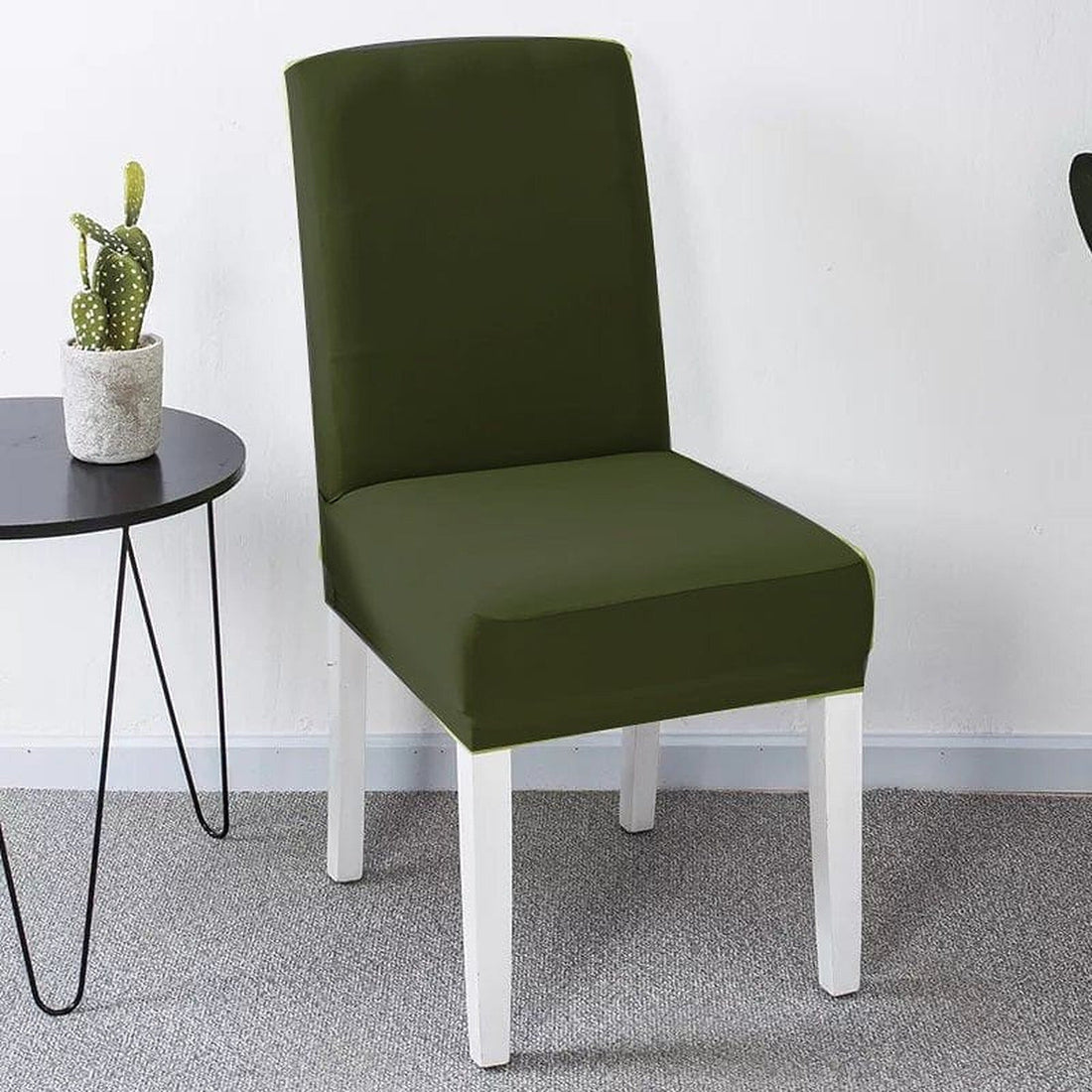 Forest green stretch dining chair cover fitted over a dining chair