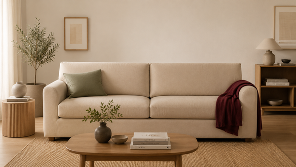 Covaba calm living room in warm neutrals with ivory walls, oak floor, beige sofa cover, sage cushion accent and a bordeaux throw