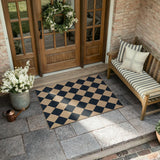 Covaba geometric checkered easy jute indoor/outdoor doormat in ink black, styled in a room setting, view 2
