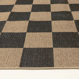 Covaba checkered easy jute natural indoor/outdoor rug in ink black, styled in a room setting