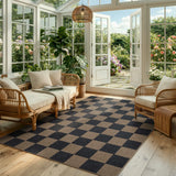 Covaba checkered easy jute indoor/outdoor area rug in coffee brown, styled in a room setting, view 9