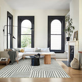 Covaba abstract rainbow stripe black/beige area rug in warm beige, styled in a room setting, view 6