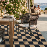 Covaba checkered easy jute natural indoor/outdoor area rug in ink black, styled in a room setting, view 5