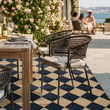 Covaba geometric checkered easy jute indoor/outdoor area rug in ink black, styled in a room setting, view 7