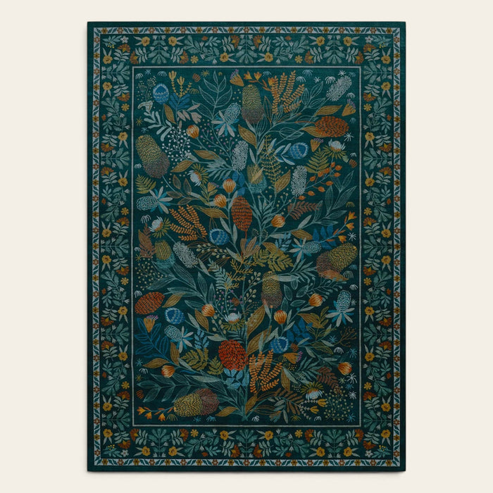 Covaba modern botanical floral area rug in stormy blue, shown flat on a plain ivory backdrop