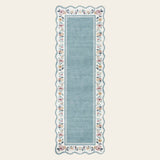 Covaba vintage floral scalloped runner rug in dusty blue, shown flat on a plain ivory backdrop