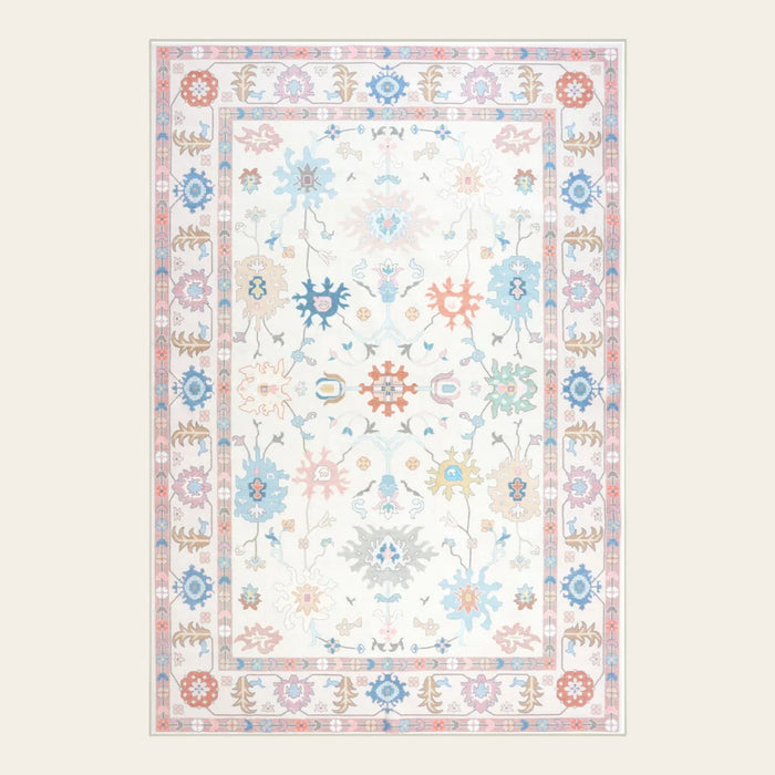 Covaba boho oushak floral area rug in blush clay, shown flat on a plain ivory backdrop