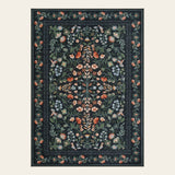 Covaba vintage floral area rug in ink black, shown flat on a plain ivory backdrop