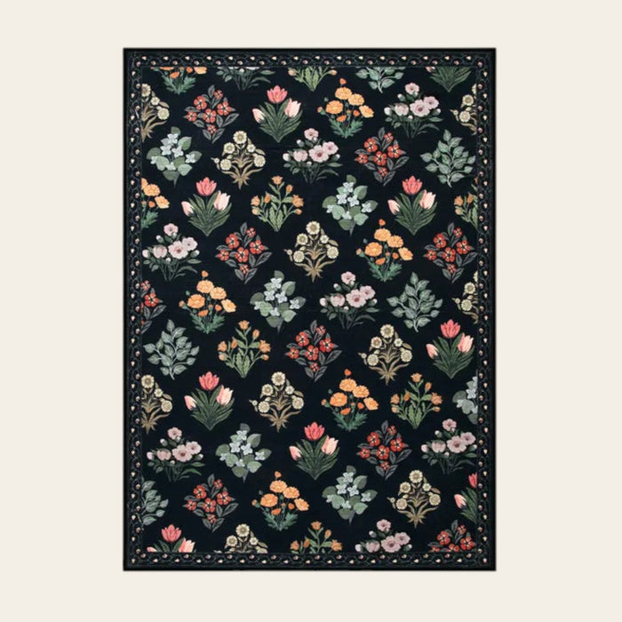 Covaba meadow floral area rug in ink black, shown flat on a plain ivory backdrop