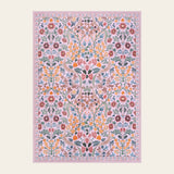 Covaba maximalism vibrant blossom floral area rug in blush clay, shown flat on a plain ivory backdrop