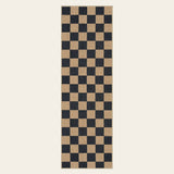Covaba checkered easy jute natural indoor/outdoor runner rug in ink black, shown flat on a plain ivory backdrop