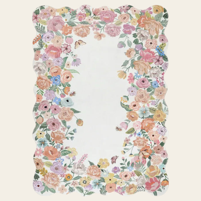 Covaba cottagecore floral scalloped area rug in ivory cream, shown flat on a plain ivory backdrop