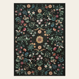 Covaba boho botanical floral area rug in ink black, shown flat on a plain ivory backdrop