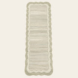 Covaba modern abstract bordered scalloped runner rug in warm beige, shown flat on a plain ivory backdrop