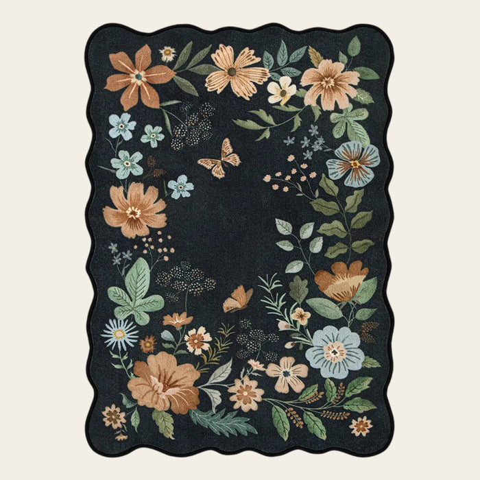 Covaba boho modern parisian floral scalloped area rug in ink black, shown flat on a plain ivory backdrop
